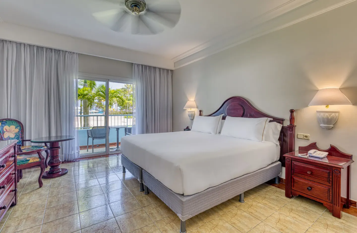 Senator Puerto Plata at Senator Puerto Plata with king bed, bedside tables, sitting area, and balcony.