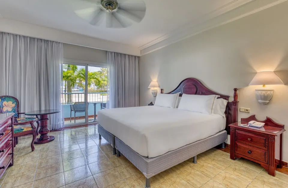 Senator Puerto Plata at Senator Puerto Plata with king bed, bedside tables, sitting area, and balcony.