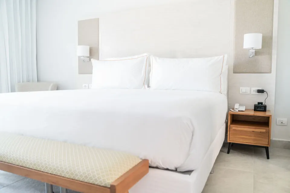 Luxury Junior Suite Ocean View king bed and nightstand at Senator Puerto Plata.