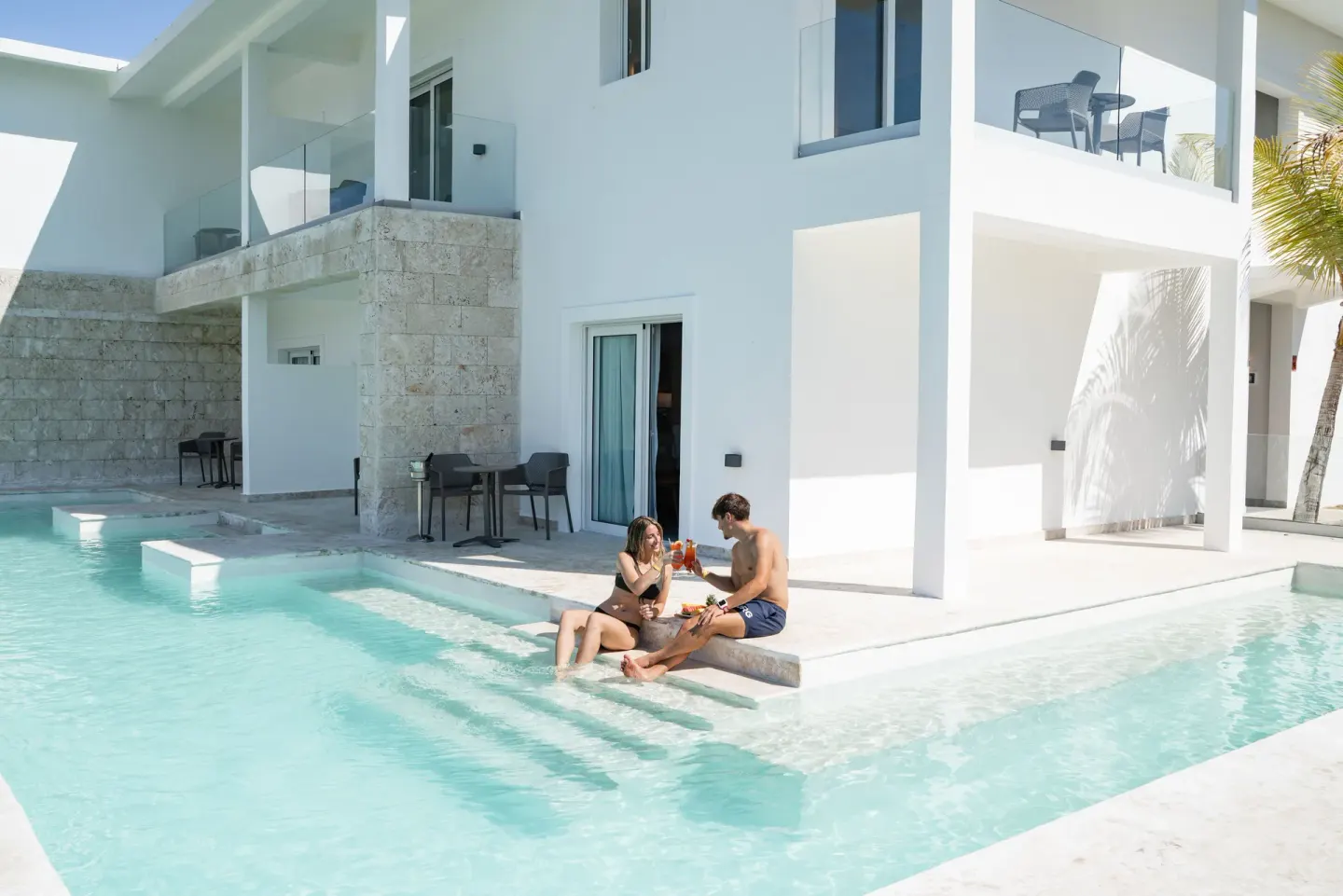 Swim-up suite patio and pool steps at Senator Puerto Plata with guests by the water.