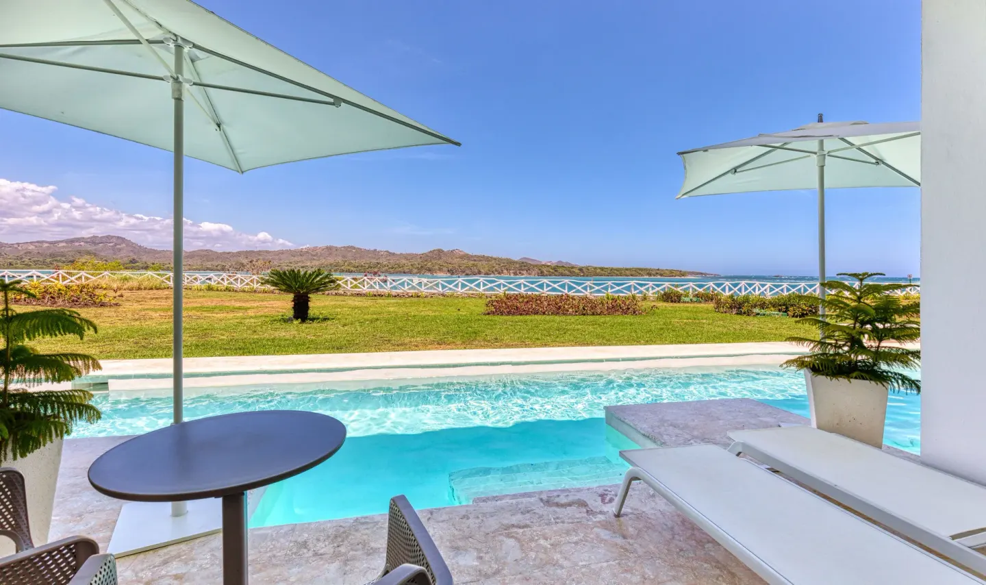 Swim-up suite terrace at Senator Puerto Plata overlooking the pool, lawn and ocean.