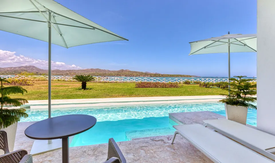 Swim-up suite terrace at Senator Puerto Plata overlooking the pool, lawn and ocean.