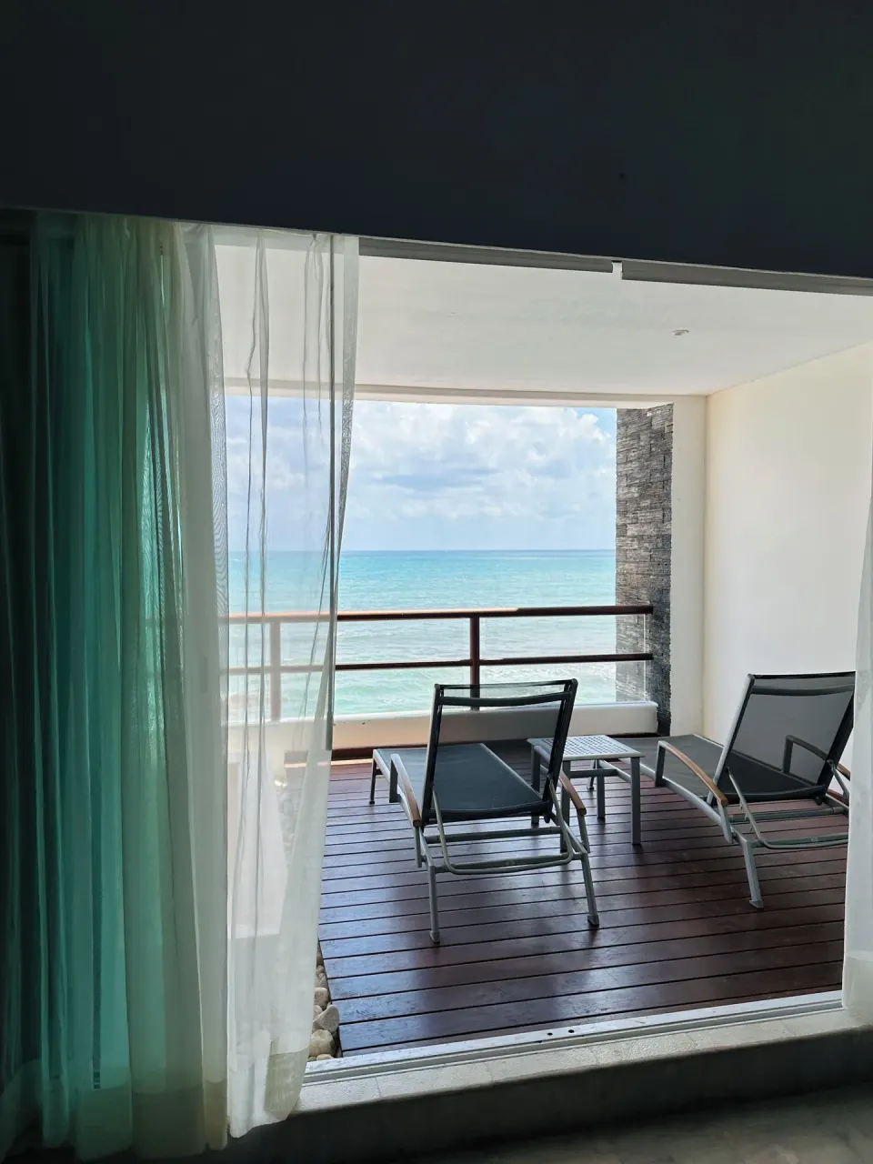 Covered balcony with two loungers overlooks the sea at Senses Riviera Maya Oceanfront.