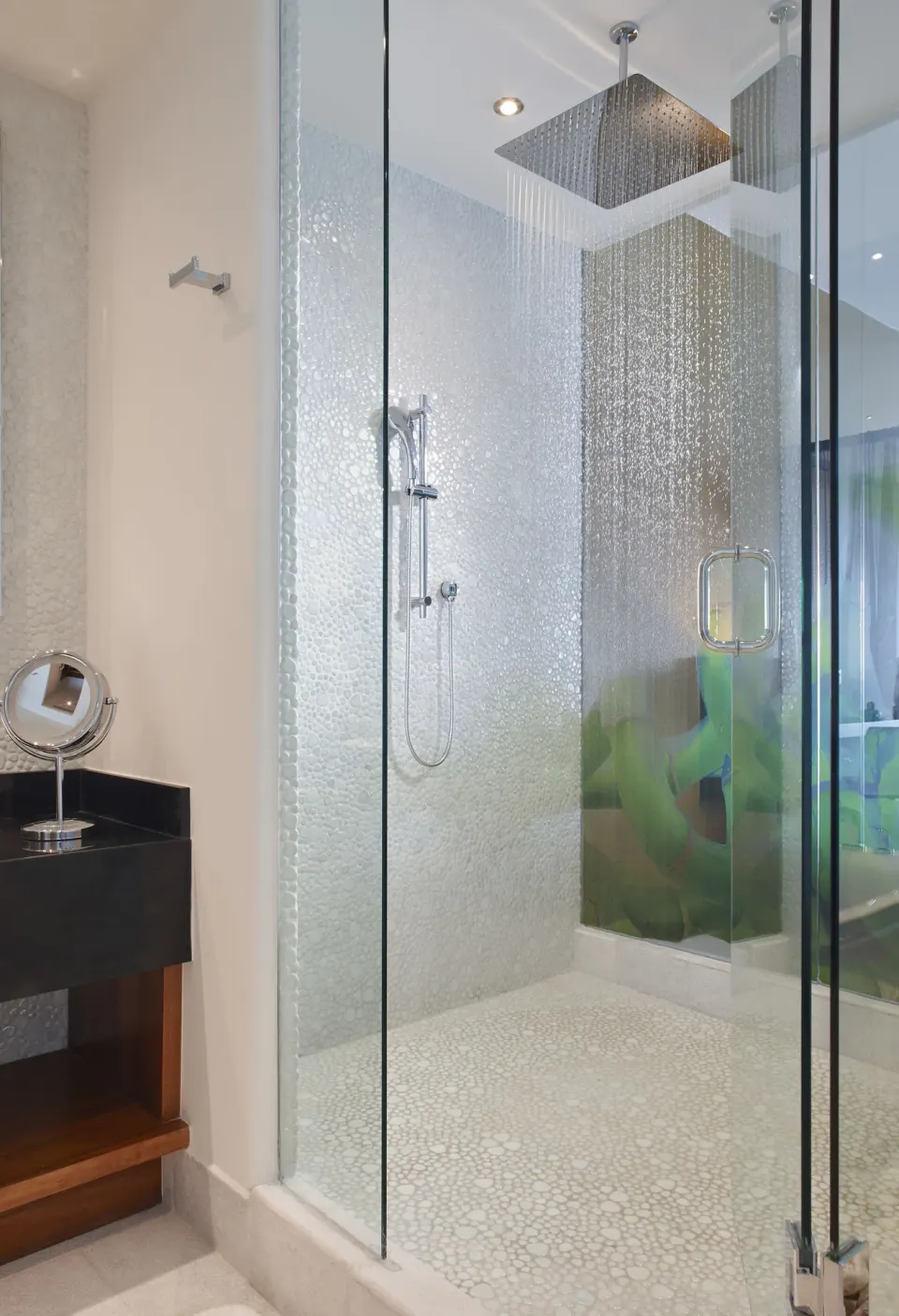 Glass-enclosed rainfall shower in a guest bathroom at Senses Riviera Maya Oceanfront.