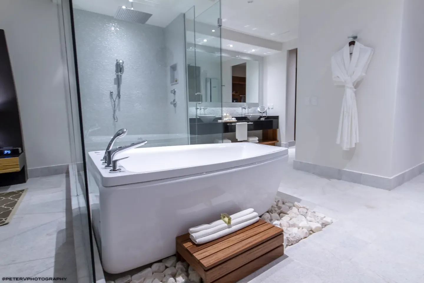 Bathroom with soaking tub, glass shower, and robe at Senses Riviera Maya Oceanfront.