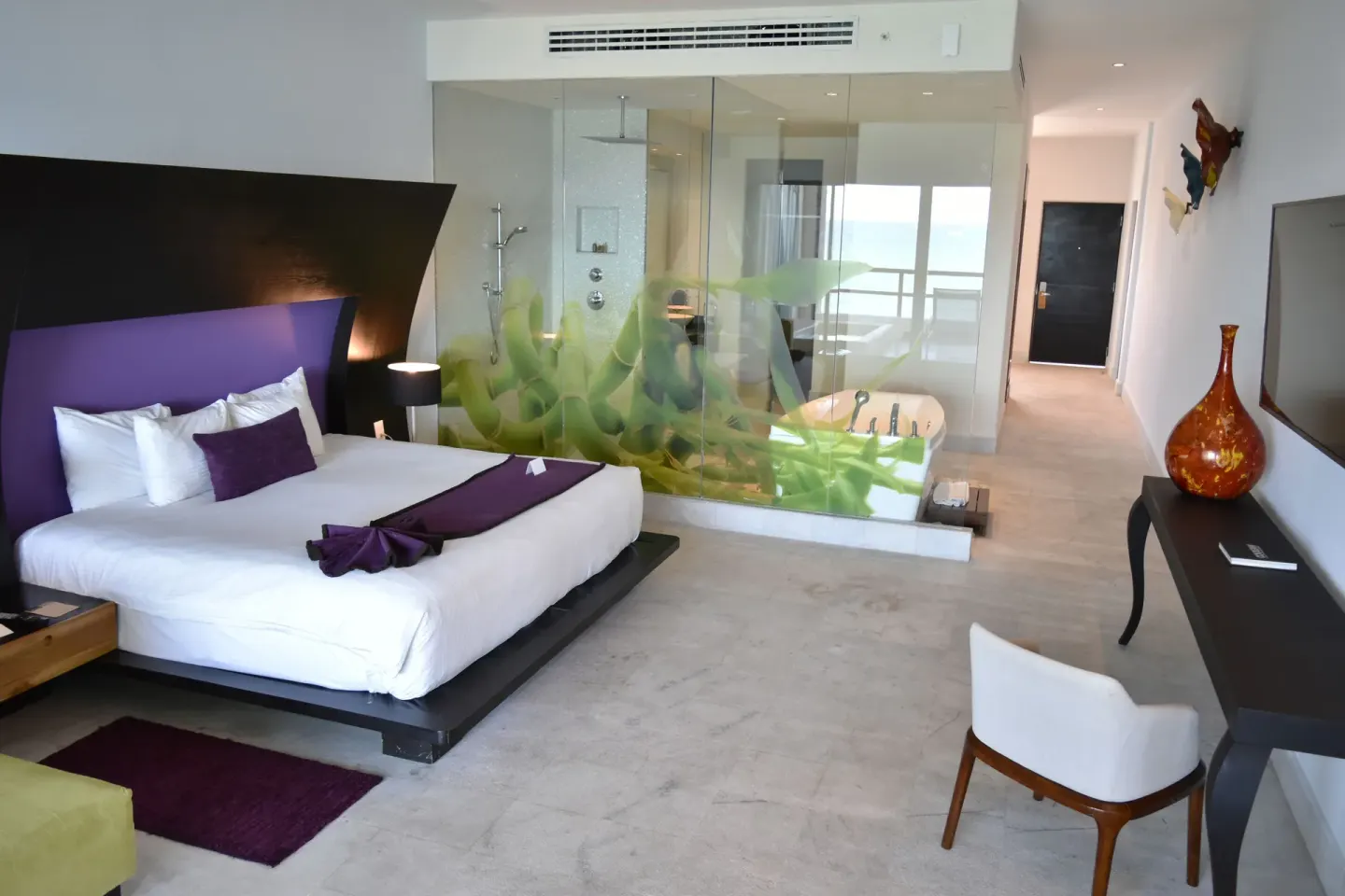 Guest room with king bed, soaking tub, and ocean beyond at Senses Riviera Maya Oceanfront.