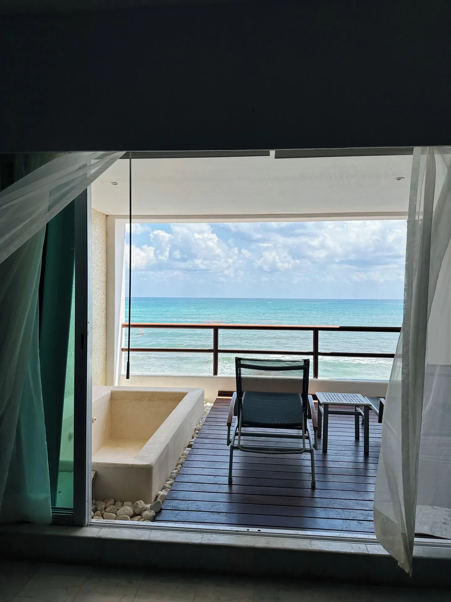 Oceanfront balcony with lounger and soaking tub at Senses Riviera Maya Oceanfront.