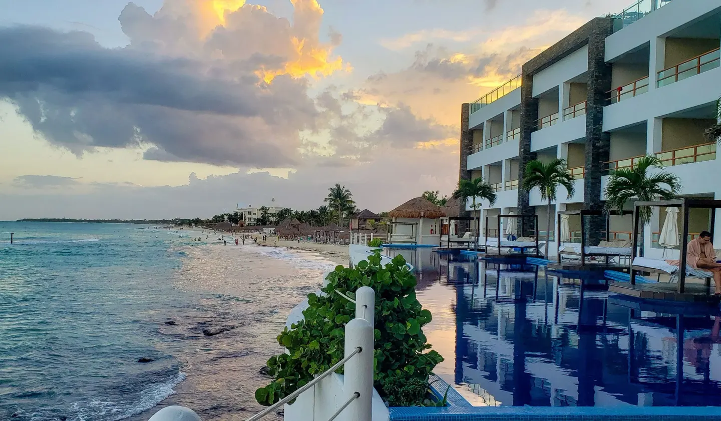 Oceanfront pool and beach at sunset at Senses Riviera Maya Oceanfront.