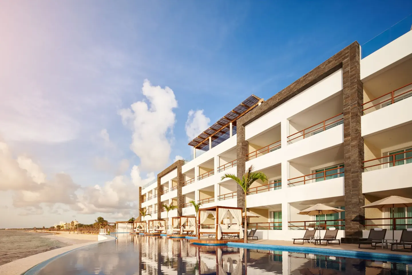 Resort building with balconies beside the pool at Senses Riviera Maya Oceanfront.