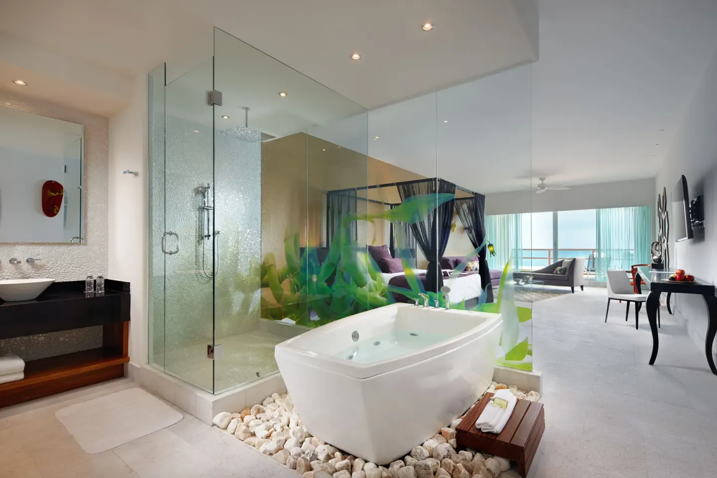 Open-plan suite with tub, glass shower, and canopy bed at Senses Riviera Maya Oceanfront.