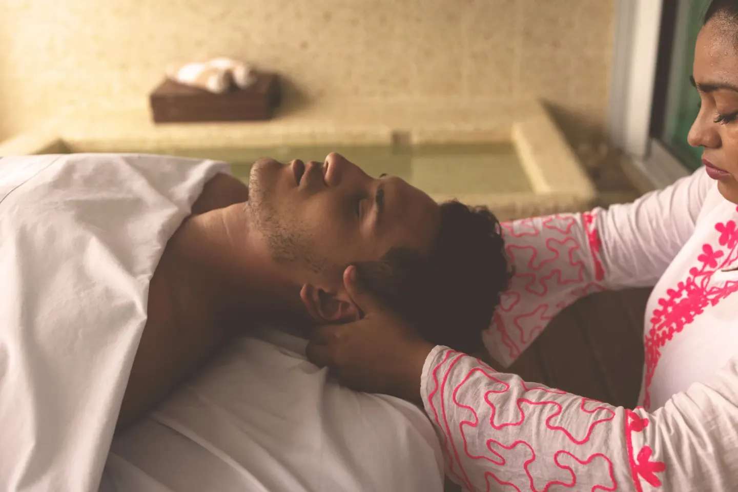 A spa therapist gives a head massage to a guest at Senses Riviera Maya Oceanfront.