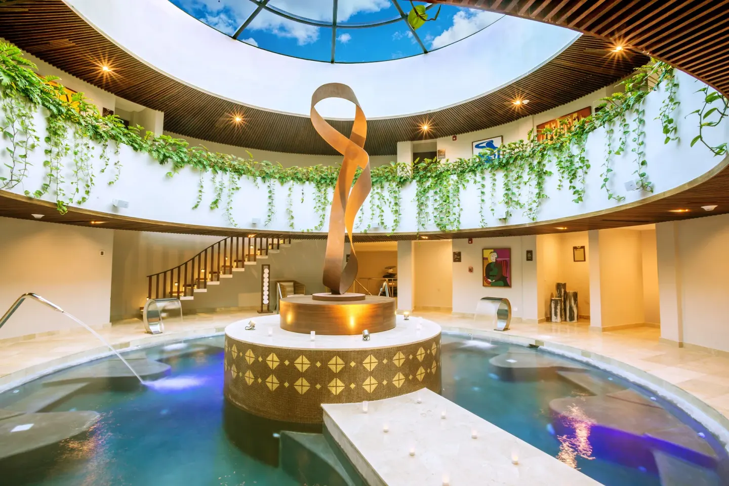 Circular indoor spa pool with skylight and greenery at Sensira Resort & Spa Riviera Maya.
