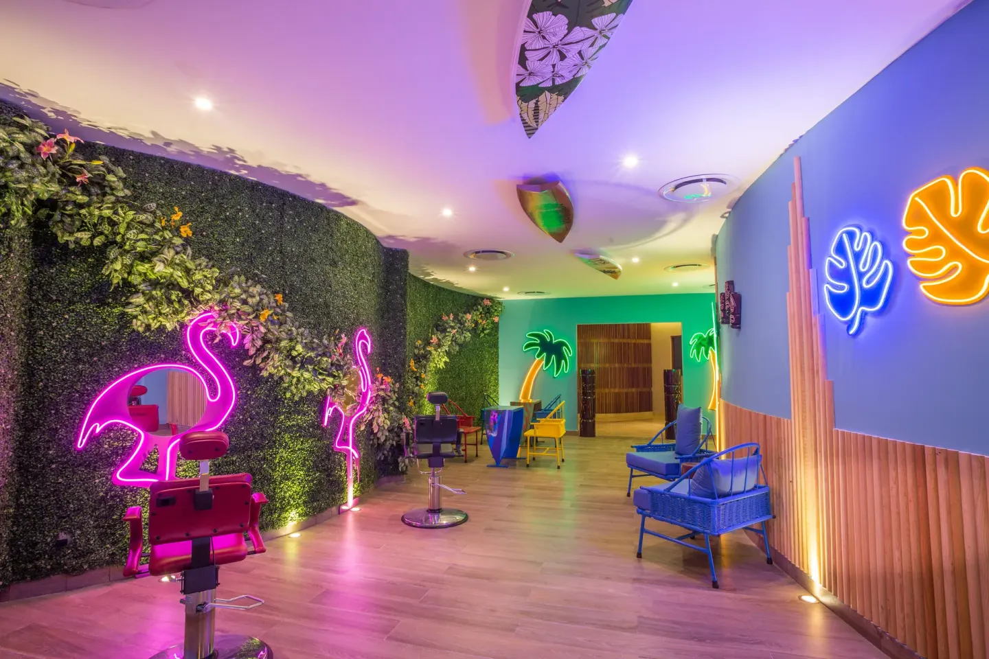 Colorful salon area with neon flamingo and palm lights at Sensira Resort & Spa Riviera Maya.