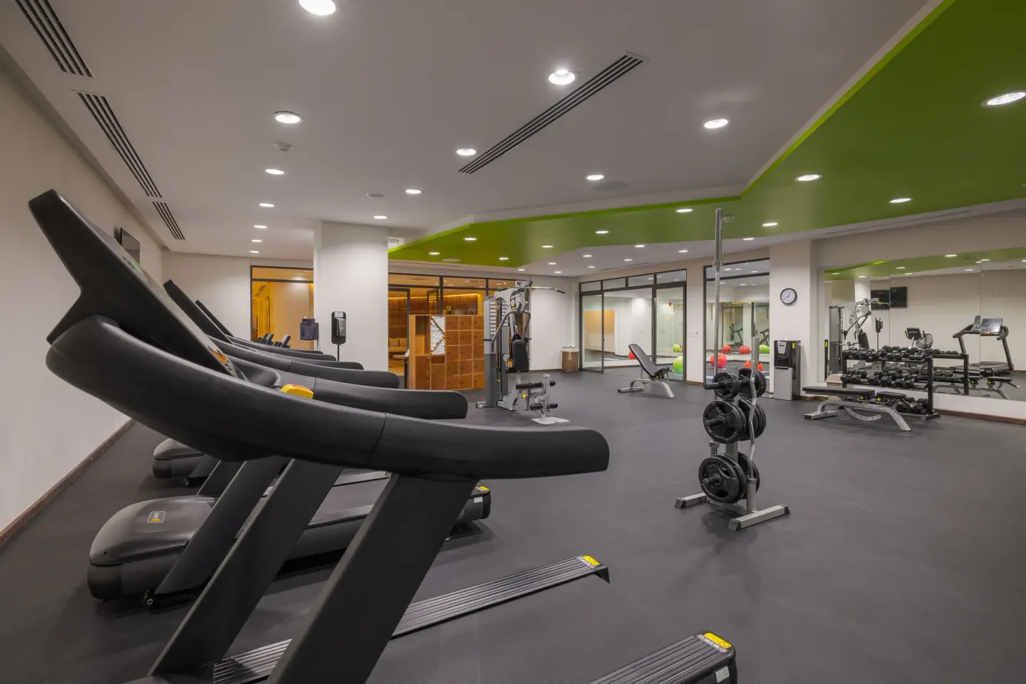 Fitness center with treadmills, weights, and mirrors at Sensira Resort & Spa Riviera Maya.