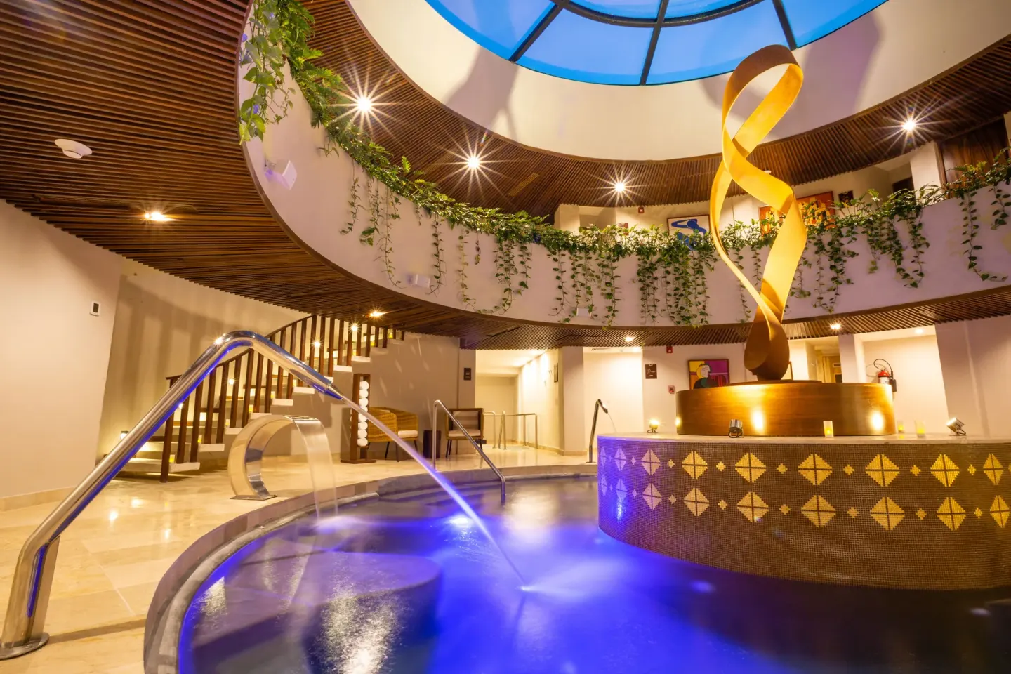 Indoor spa pool atrium with sculpture and water jets at Sensira Resort & Spa Riviera Maya.