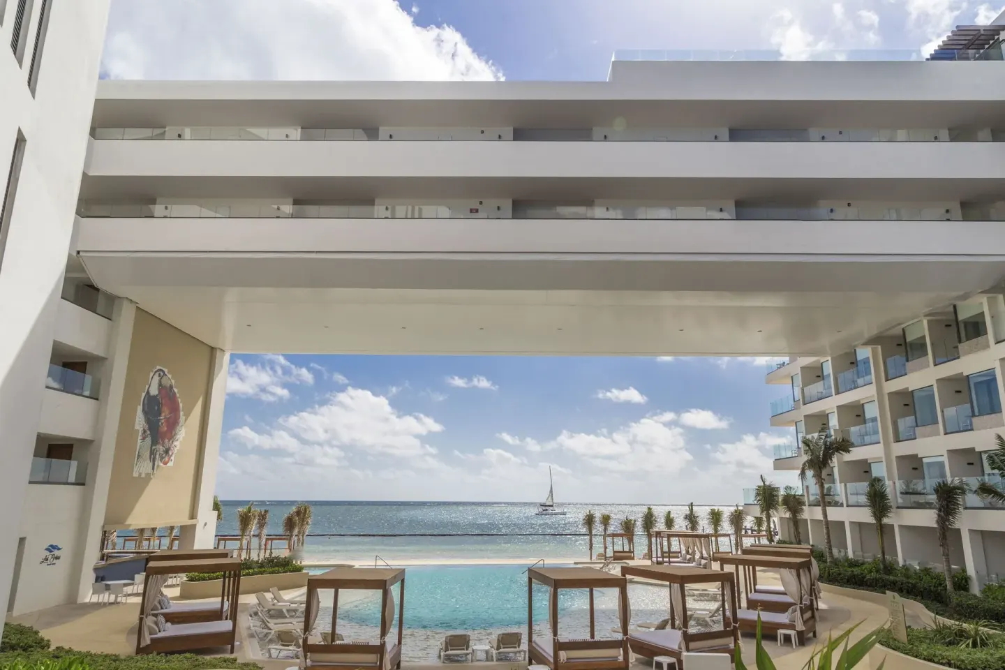 Ocean-facing pool and cabanas below the resort bridge at Sensira Resort & Spa Riviera Maya.