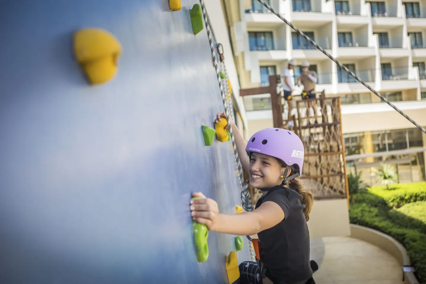 Child climbing an outdoor rock wall at Sensira Resort & Spa Riviera Maya.