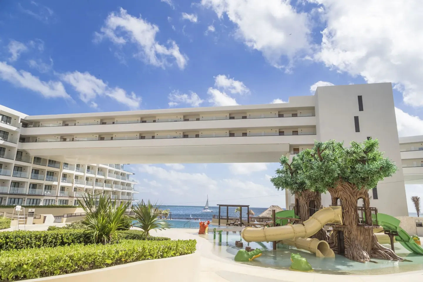 Water play area and resort bridge with ocean beyond at Sensira Resort & Spa Riviera Maya.