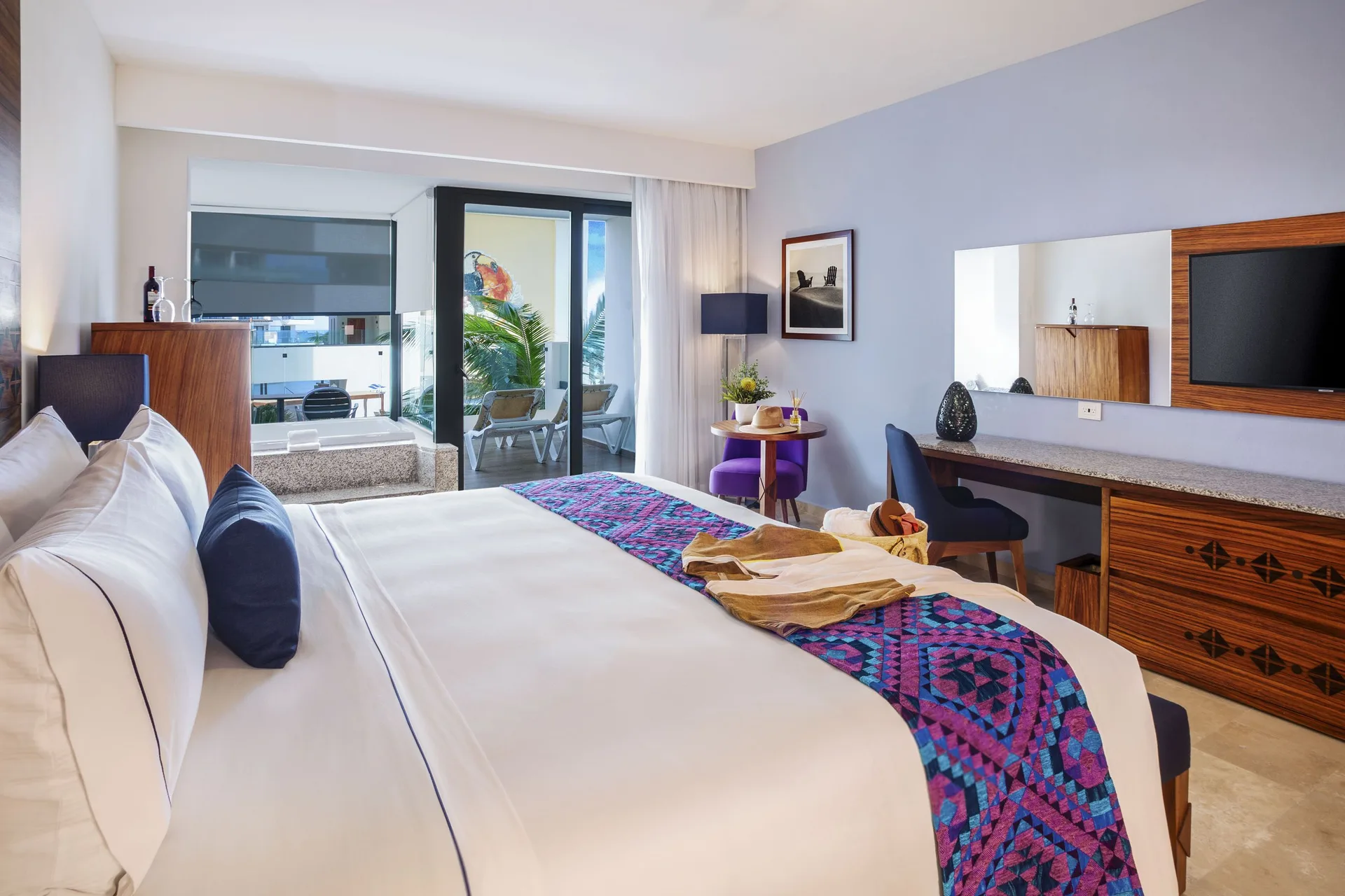 Amber Room king bed with desk, wall mirror, and balcony at Sensira Resort & Spa Riviera Maya.