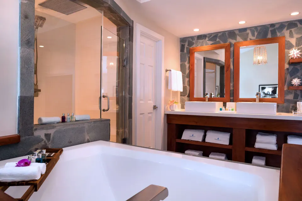 Resort bathroom with freestanding tub, dual sinks and glass shower at Serenity At Coconut Bay