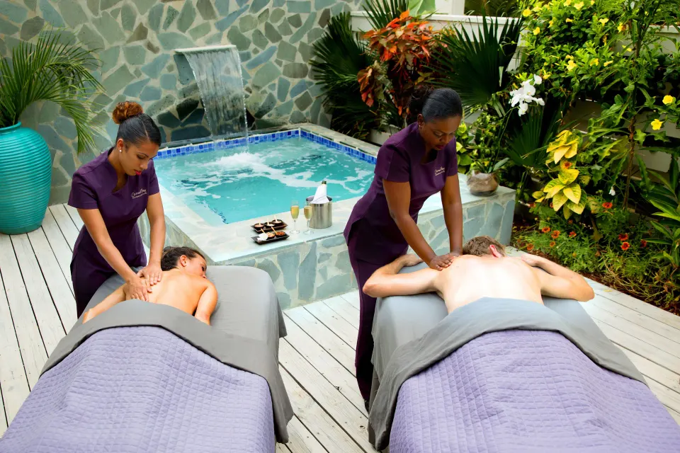 Outdoor couple's massage area beside a hot tub at Serenity At Coconut Bay.
