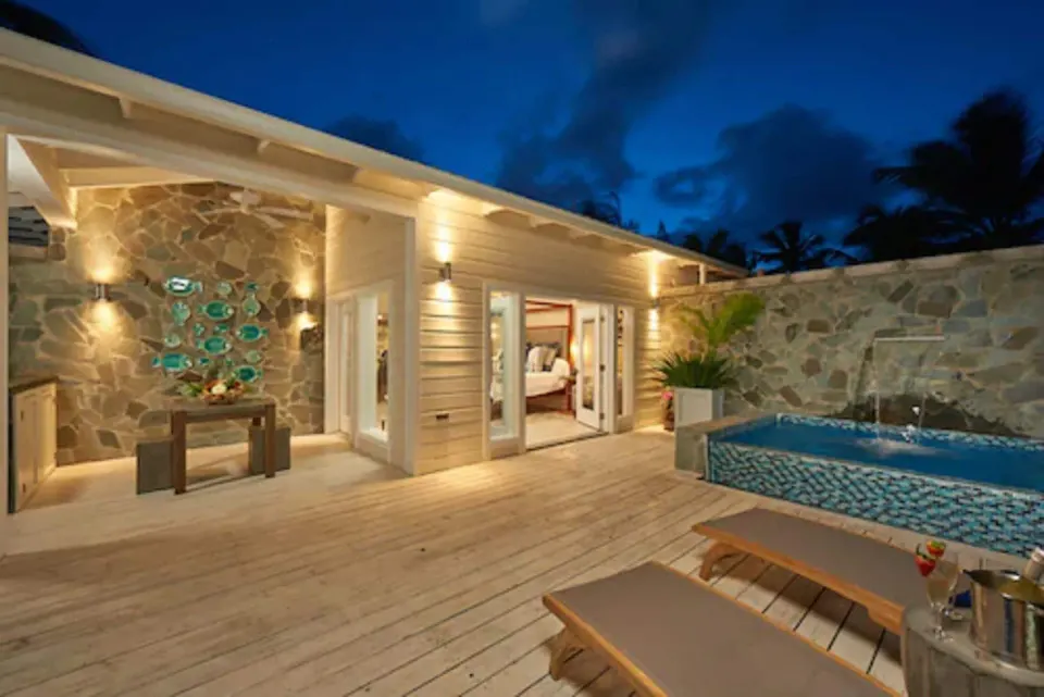 Night view of villa deck with illuminated pool and loungers at Serenity At Coconut Bay