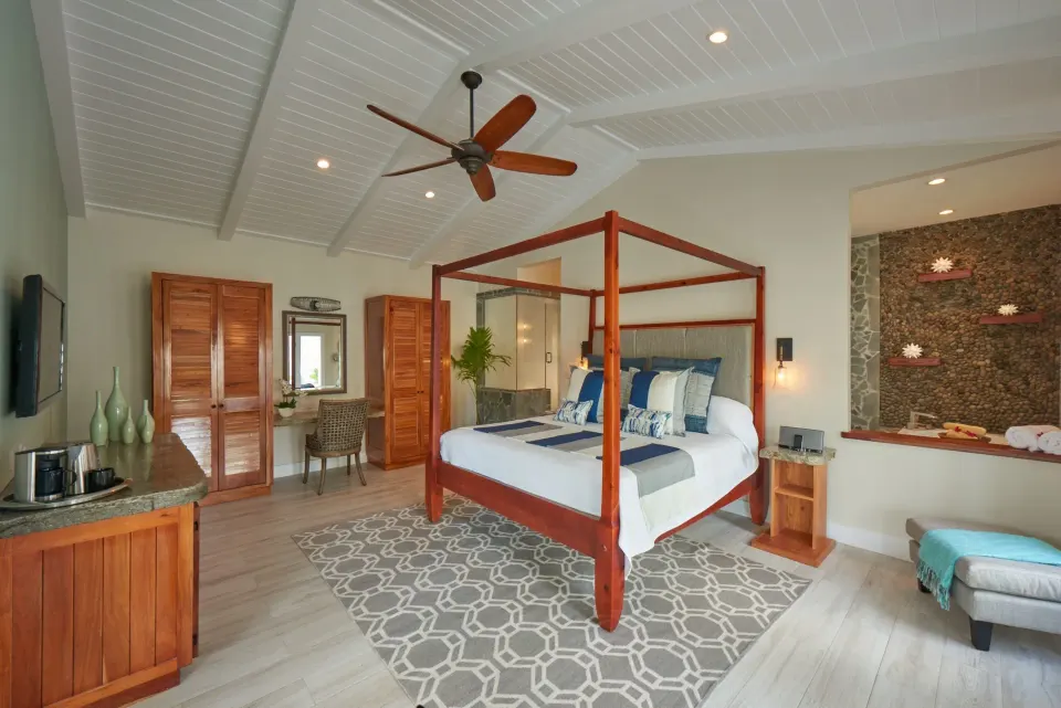 Bright suite with four-poster king bed and wardrobe at Serenity At Coconut Bay