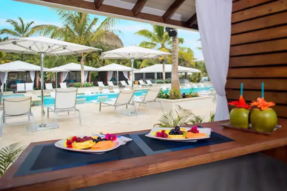 Poolside cabanas, lounge chairs, and tropical landscaping at Serenity At Coconut Bay.