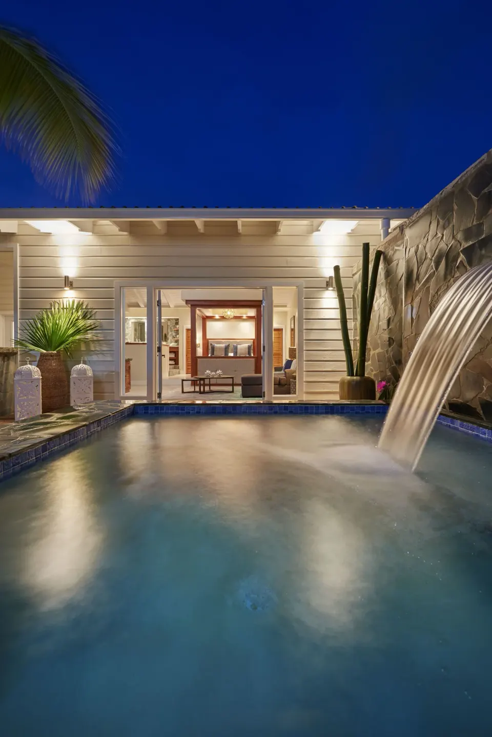 Night view of private pool with waterfall feature at Serenity At Coconut Bay