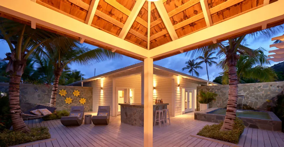 Lit outdoor lounge and deck area around a private villa pool at Serenity At Coconut Bay