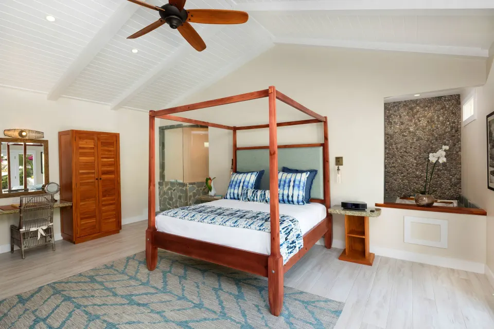 Four-poster bed and dressing area in a bright suite at Serenity At Coconut Bay