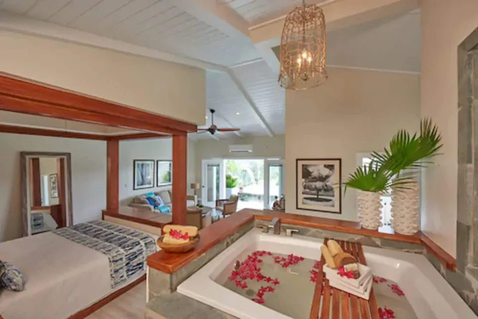 Suite interior with in-room tub and king bed at Serenity At Coconut Bay