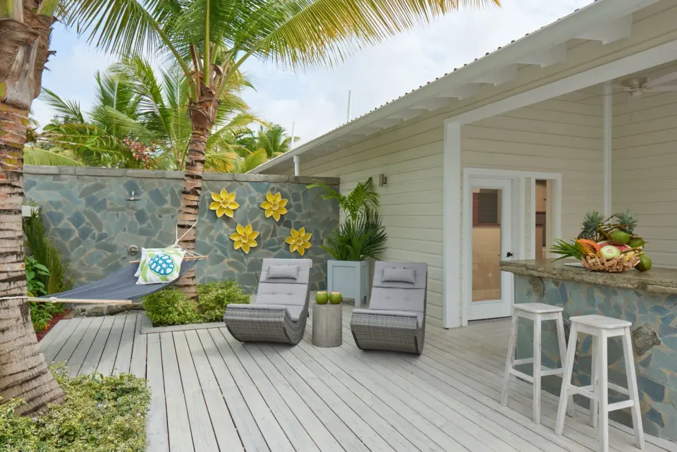 Daytime villa deck with loungers, hammock and bar counter at Serenity At Coconut Bay