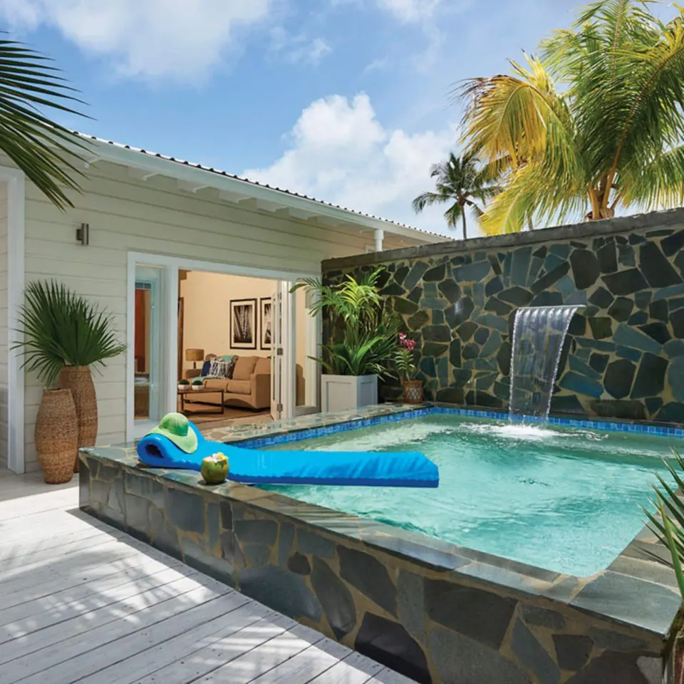 Private plunge pool with waterfall feature opening to villa interior at Serenity At Coconut Bay