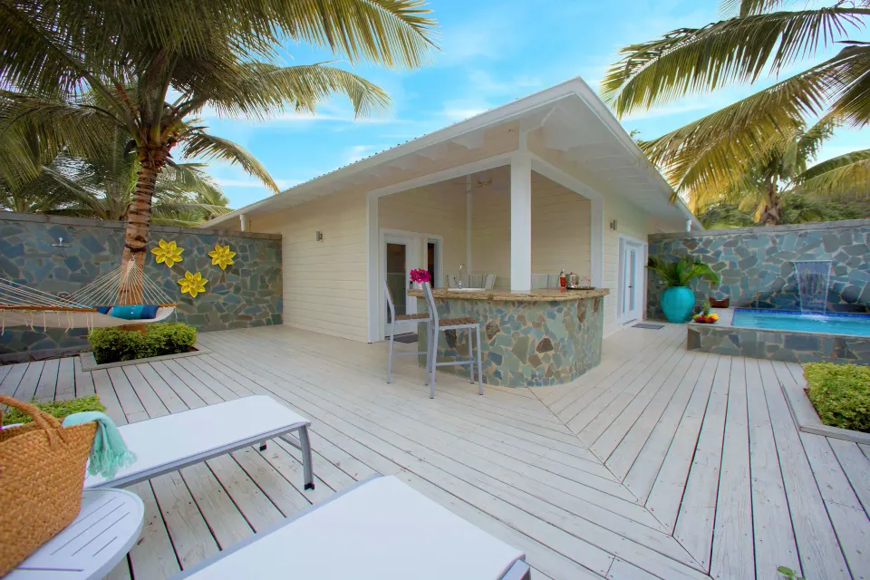 Private deck with bar, loungers and palm trees at the Plunge Pool Butler Suite at Serenity At Coconut Bay.