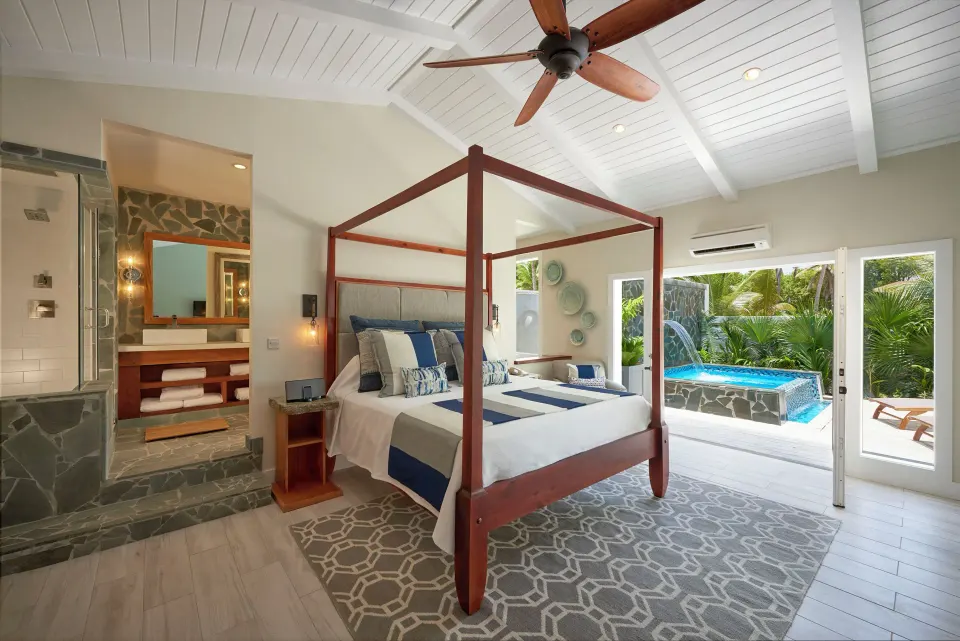 Canopied king bed with open doors to private plunge pool terrace at Serenity At Coconut Bay