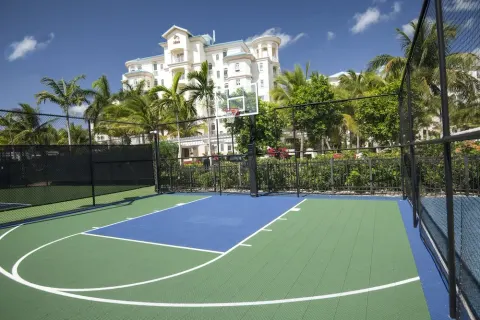 A fenced basketball court with the resort building behind it at Seven Stars Resort & Spa.