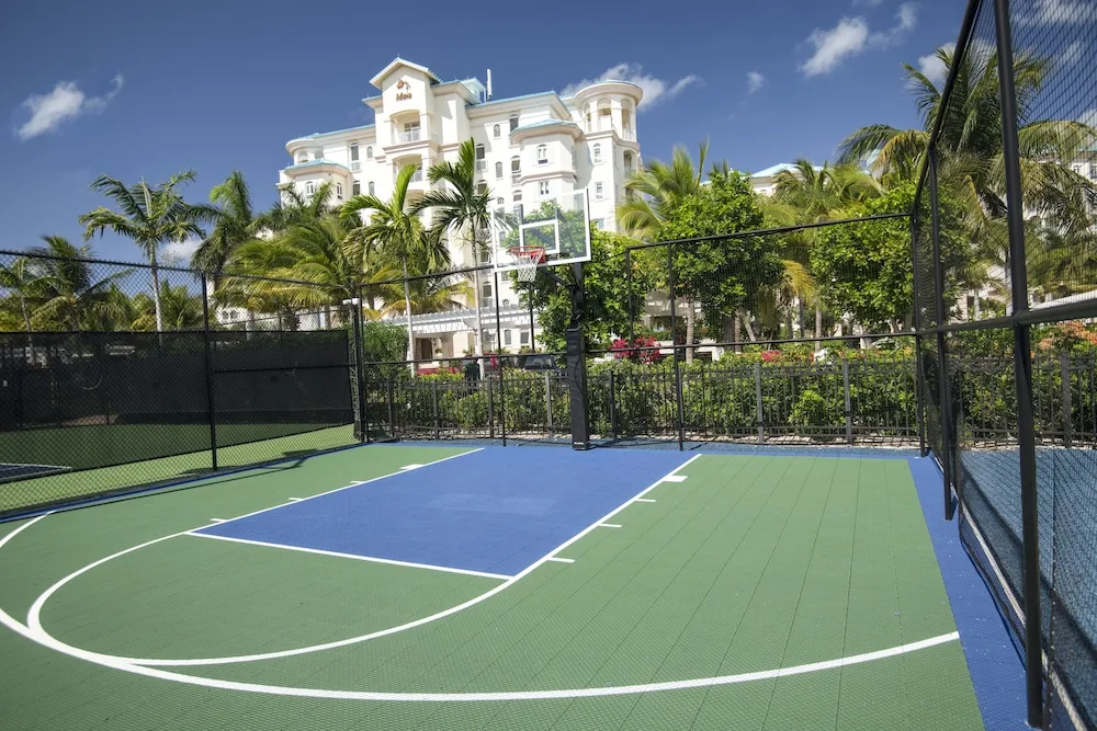 A fenced basketball court with the resort building behind it at Seven Stars Resort & Spa.