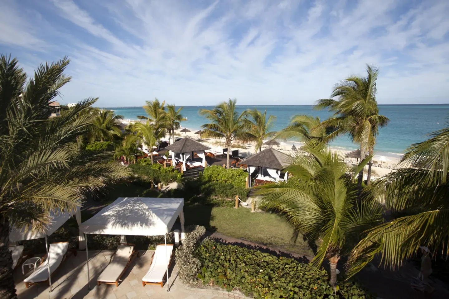 Beach garden with cabanas, palms, loungers, and ocean at Seven Stars Resort & Spa.