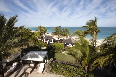 Palm-framed beach and cabana area overlooking the ocean at Seven Stars Resort & Spa.
