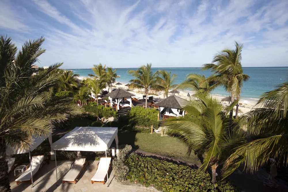 Palm-framed beach and cabana area overlooking the ocean at Seven Stars Resort & Spa.