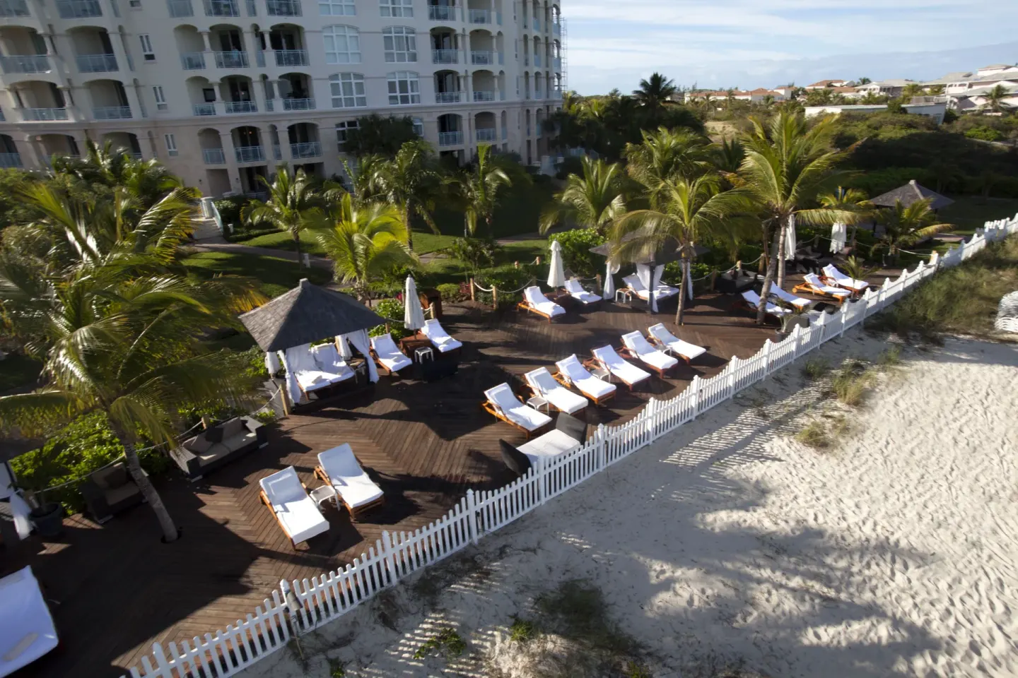 Beachfront deck with loungers and palms beside the sand at Seven Stars Resort & Spa.