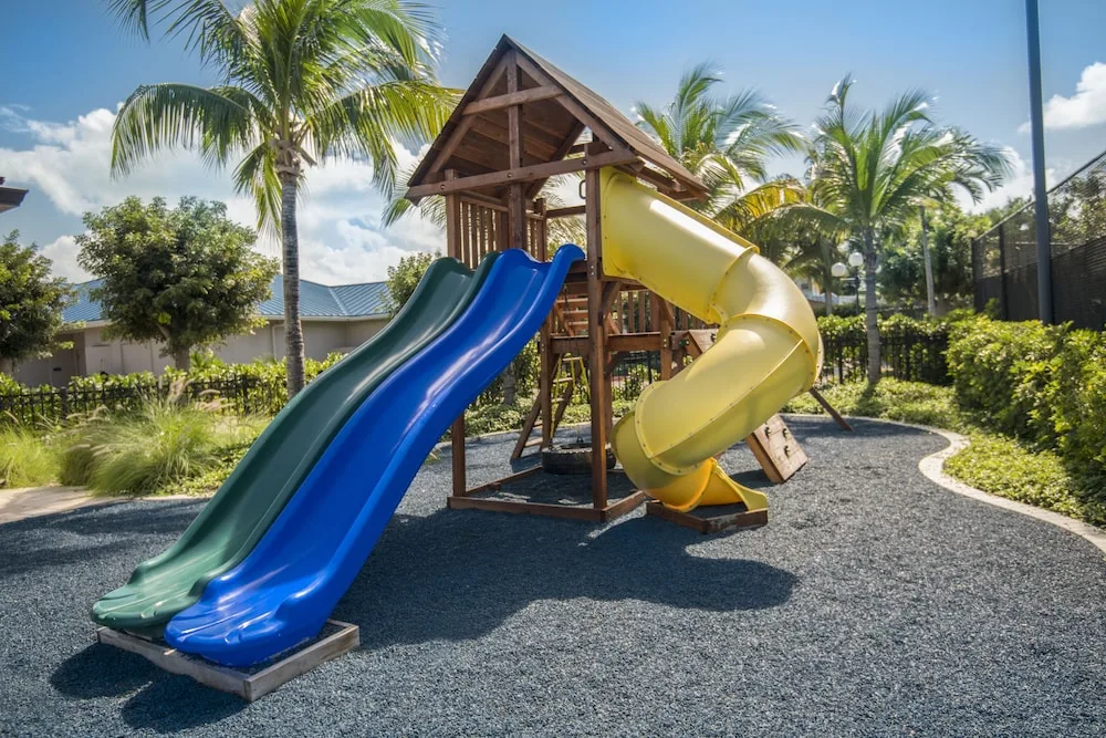 Children's playground with colorful slides and palms at Seven Stars Resort & Spa.