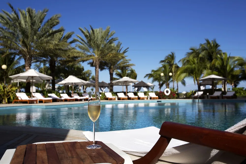 Poolside lounge chair with a drink beside the pool at Seven Stars Resort & Spa.