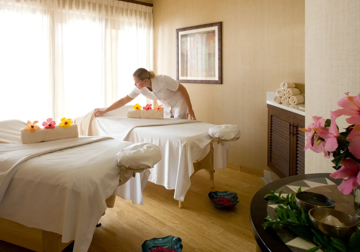 Spa attendant preparing massage tables at Seven Stars Resort & Spa.