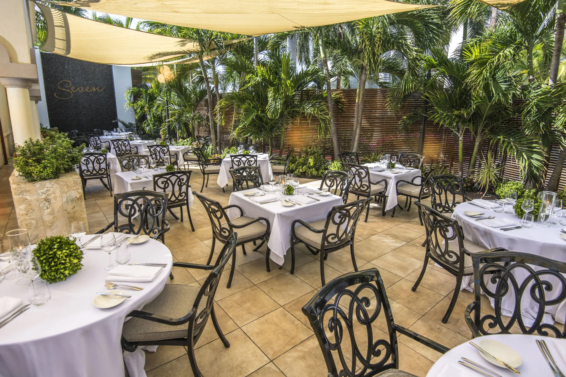 Outdoor dining terrace for Seven with white tablecloths at Seven Stars Resort & Spa.