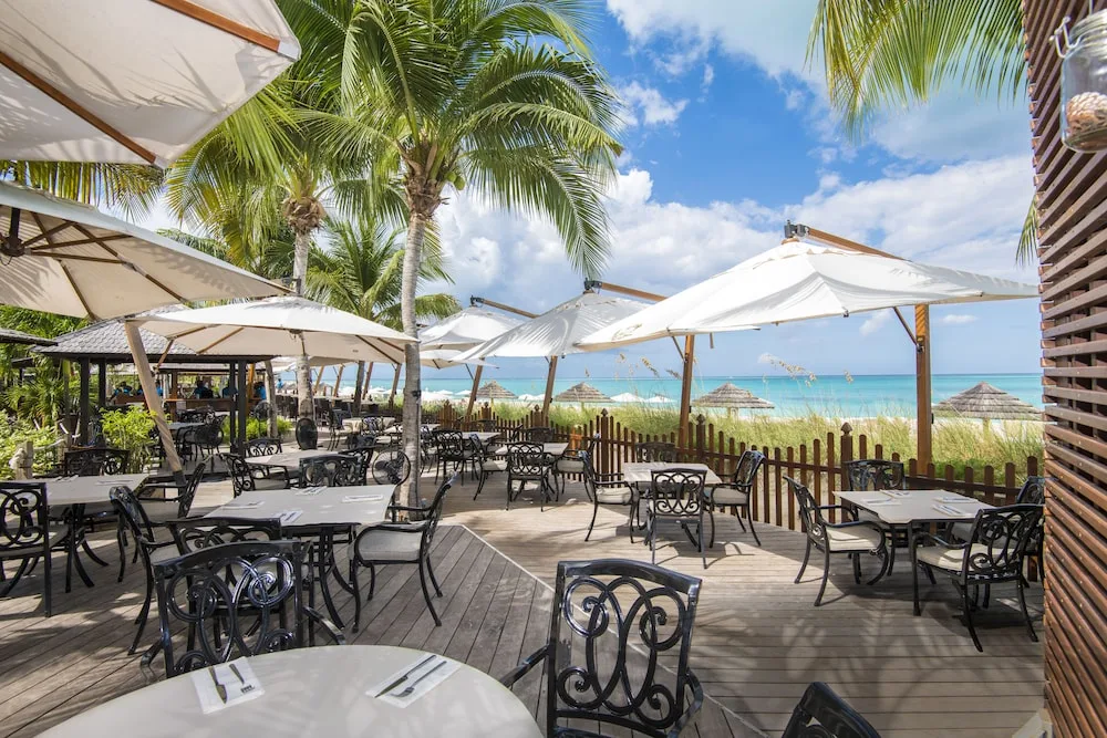 Oceanfront deck dining tables and umbrellas at Seven Stars Resort & Spa.