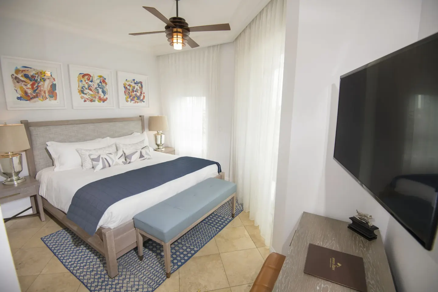 Junior Suite island view bedroom with king bed and wall-mounted TV at Seven Stars Resort & Spa.