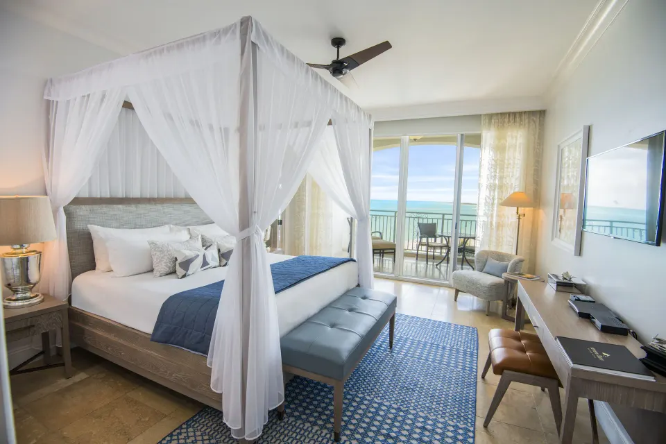 Junior Suite Oceanfront king canopy bed and balcony at Seven Stars Resort & Spa.