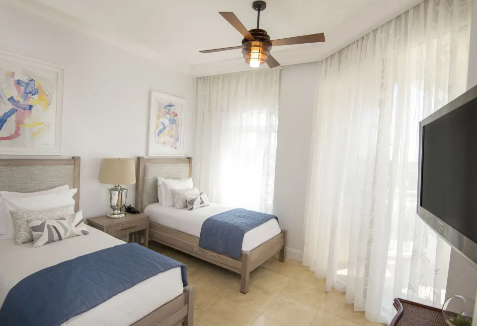 Twin bedroom in a two-bedroom island view suite at Seven Stars Resort & Spa with sheer curtains and TV.